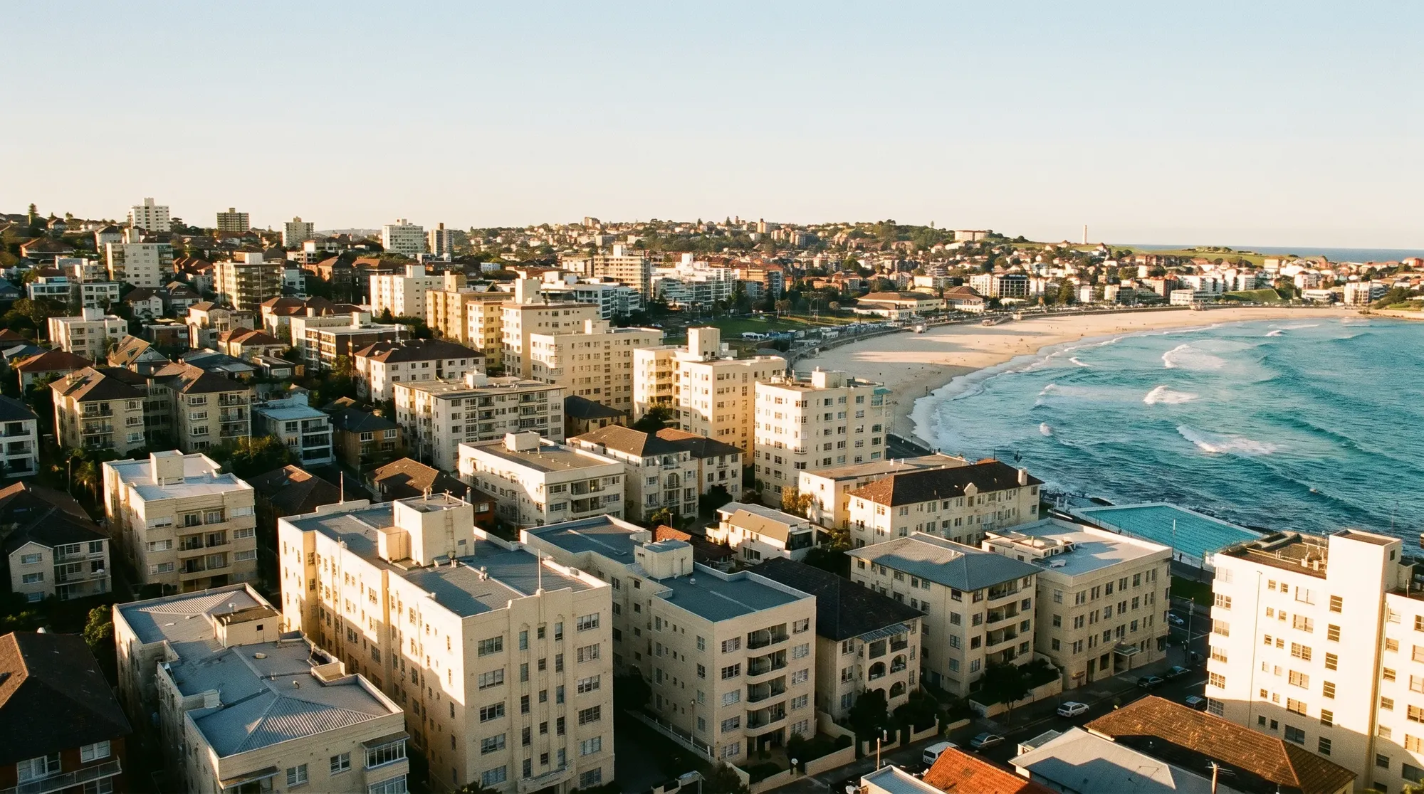 Bondi Beach with the dense art-deco apartment blocks stacked on the hill behind the surf
